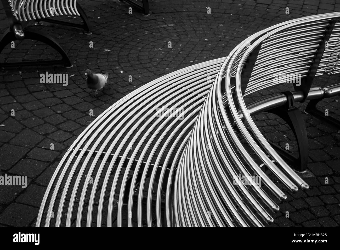 Curved steel benches in a town centre. Stock Photo