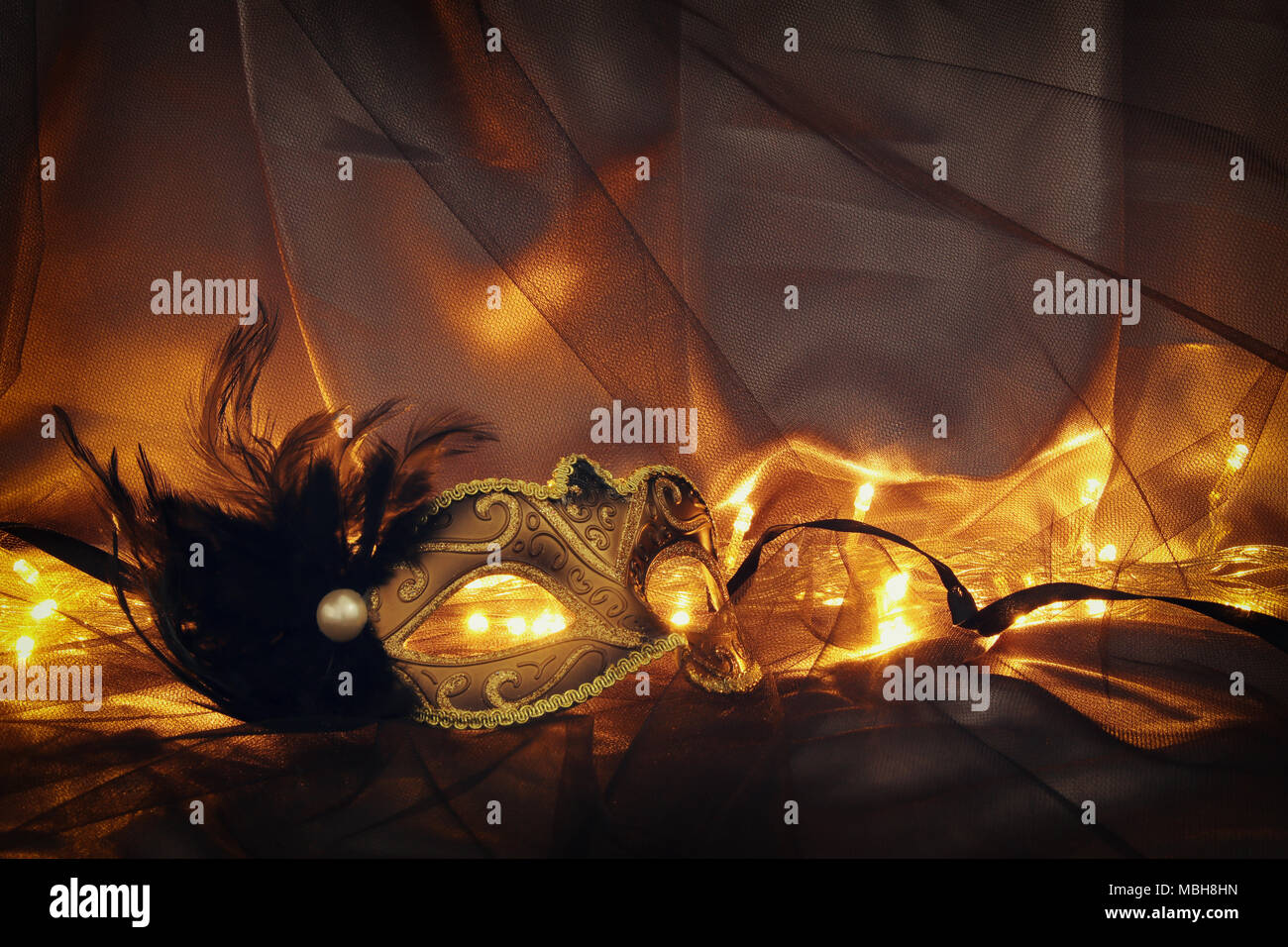 Image of elegant gold and black venetian mask over tulle background ...