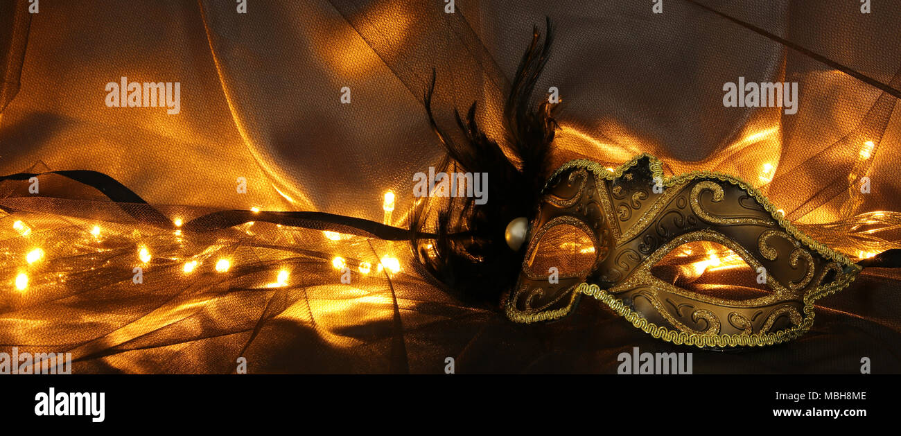 Image of elegant gold and black venetian mask over tulle background ...