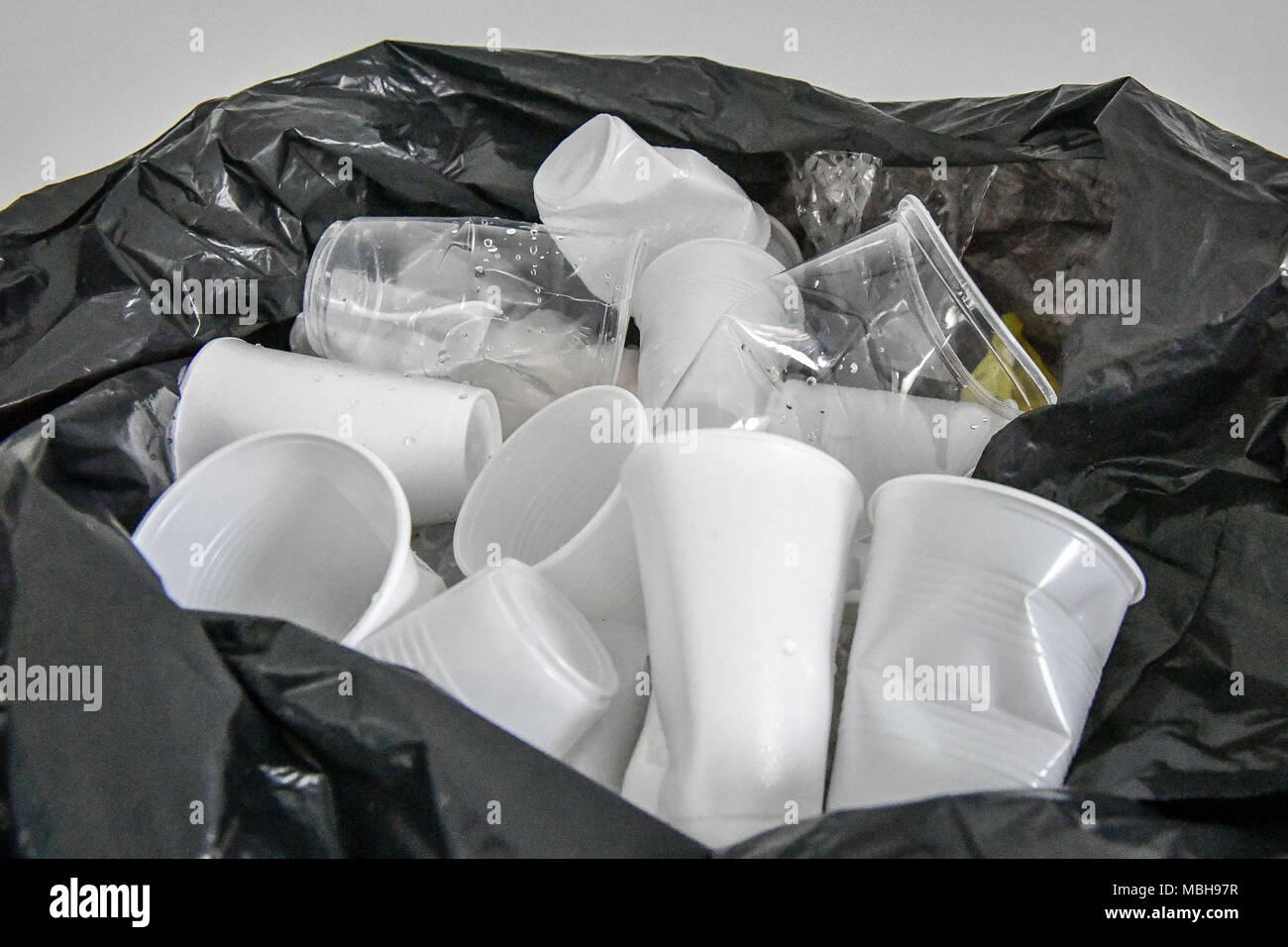 Used disposable drinking cups fill the top of a black bin bag. While NHS trusts across the country opened up about the scale of disposable cup use, Government departments were less forthcoming. Stock Photo