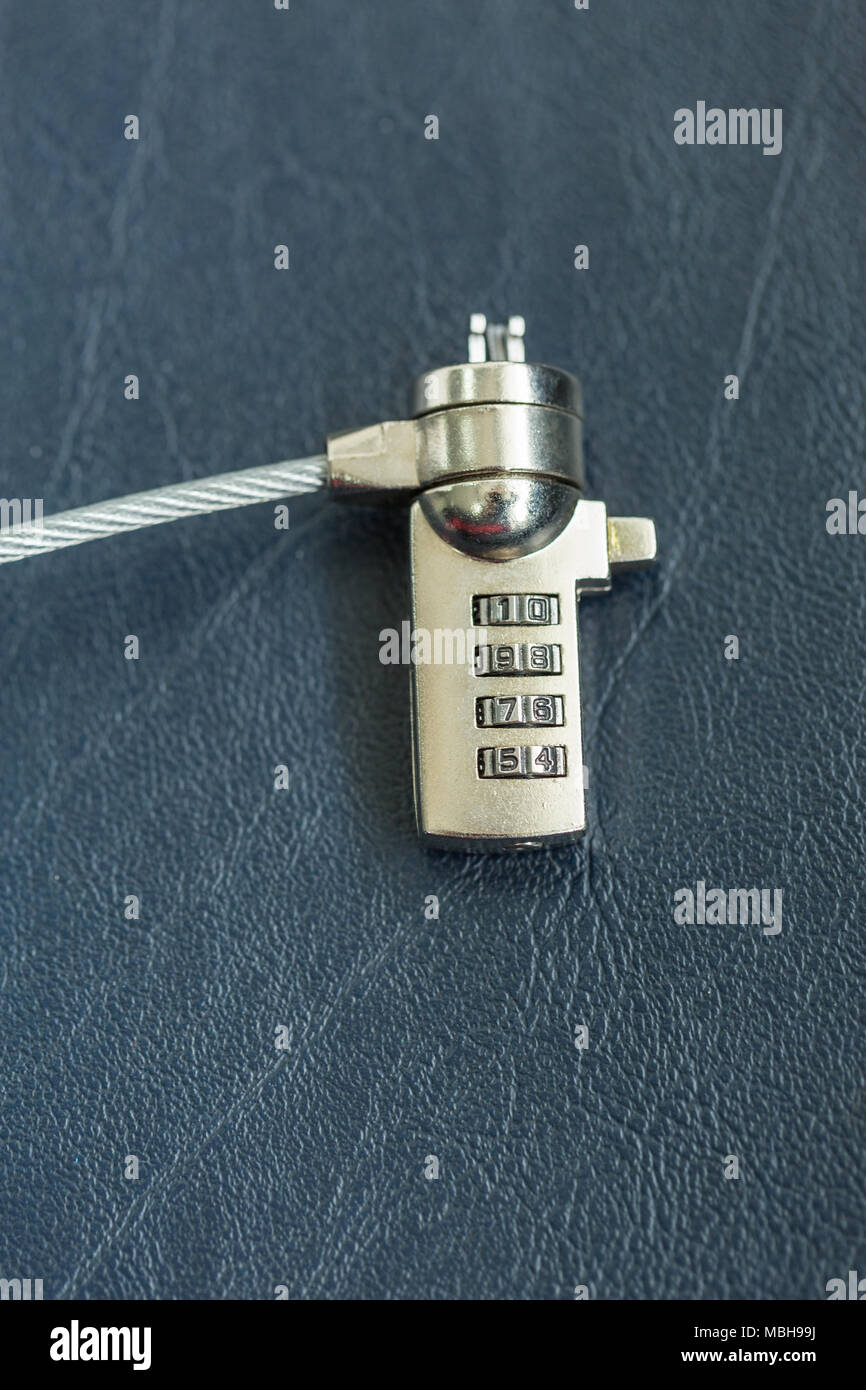 Computer cable lock on black leather, Security concept shot for the digital age Stock Photo