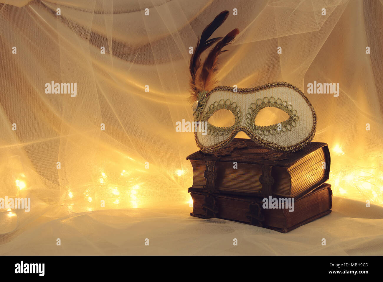 Image of elegant venetian mask over vintage old books in front of tulle ...