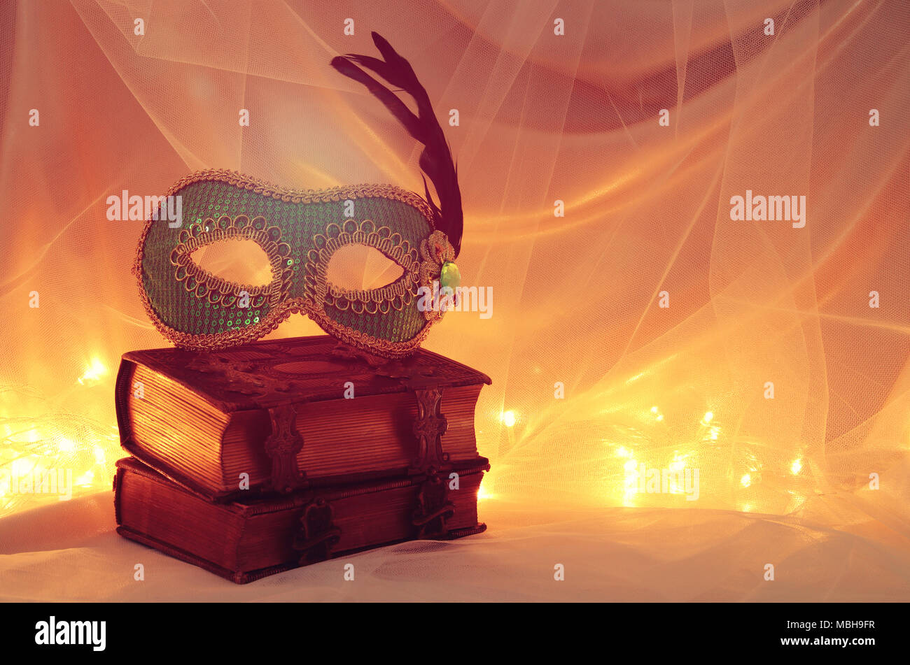 Image of elegant venetian mask over vintage old books in front of tulle ...