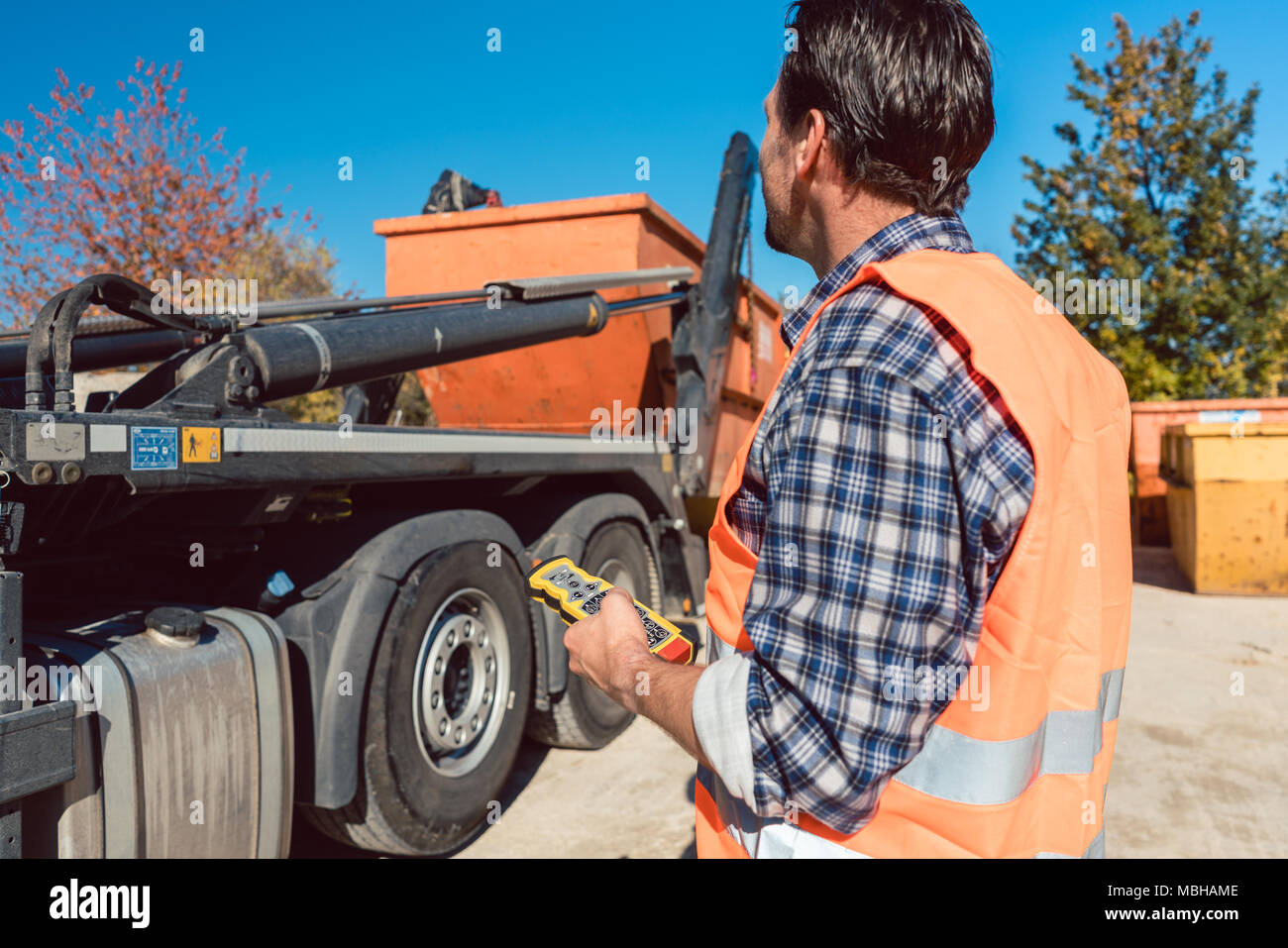 Worker On Construction Site Unloading Container For Waste From Truck Stock Photo Alamy