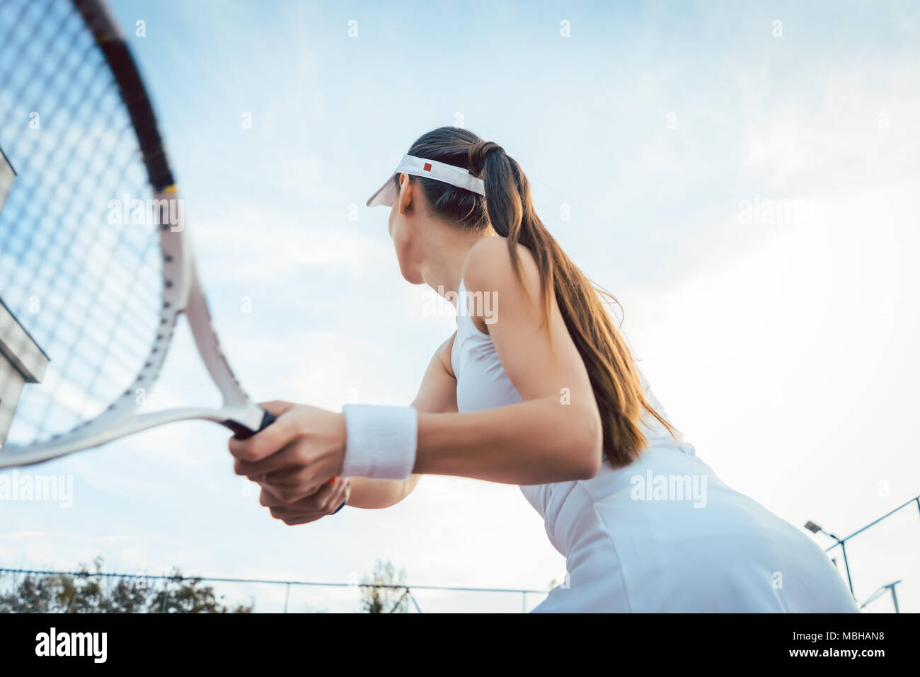 Woman giving return playing tennis Stock Photo
