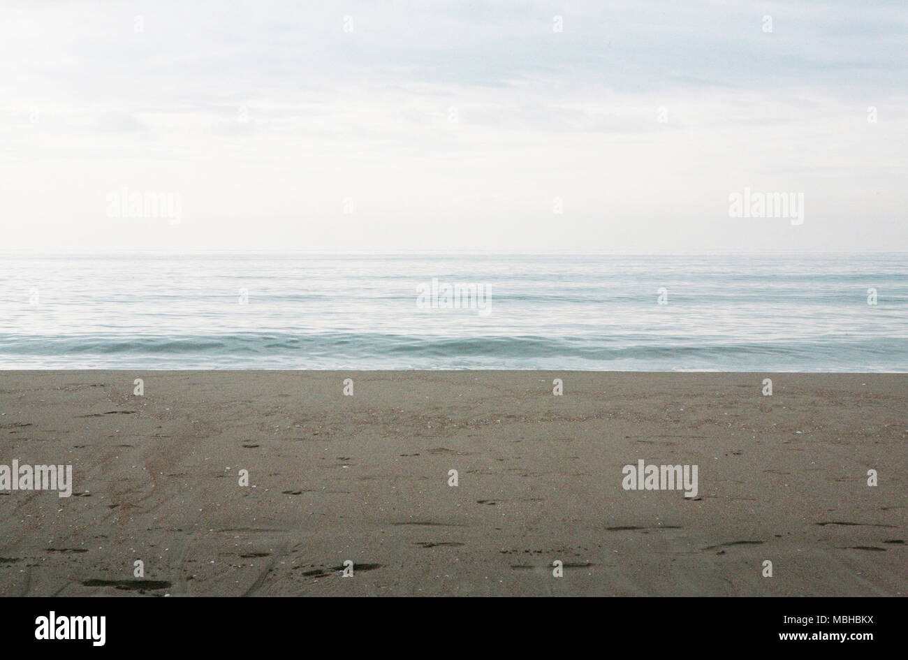Sandy beach and calm sea with clear sky Stock Photo - Alamy