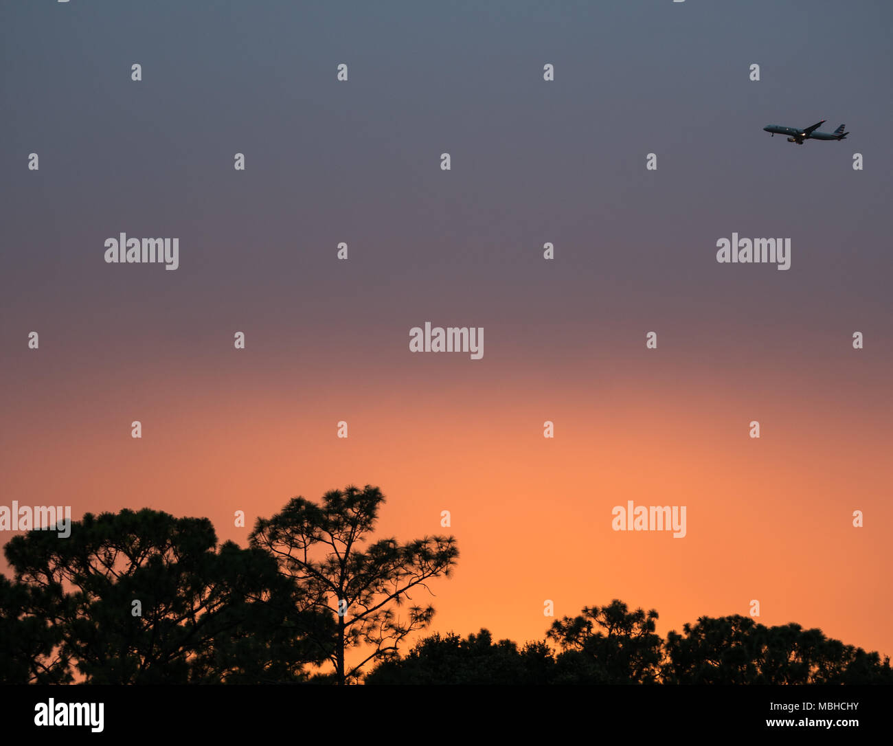 ORLANDO, FLORIDA - AUGUST 20, 2017: An American Airlines flight begins its descent to MCO International Airport at dusk. Stock Photo