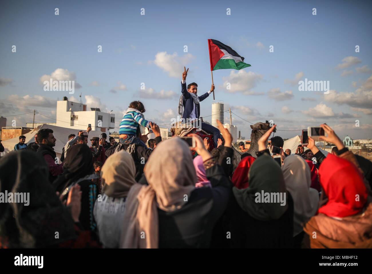 Gaza. 10th Apr, 2018. A Palestinian holds a Palestinian flag during a protest near the border between eastern Gaza and Israel, on April 10, 2018. The mass protest, known as the 'Great March of Return,' demands Palestinian refugees' right to return to their homes occupied by Israel. Credit: Wissam Nassar/Xinhua/Alamy Live News Stock Photo