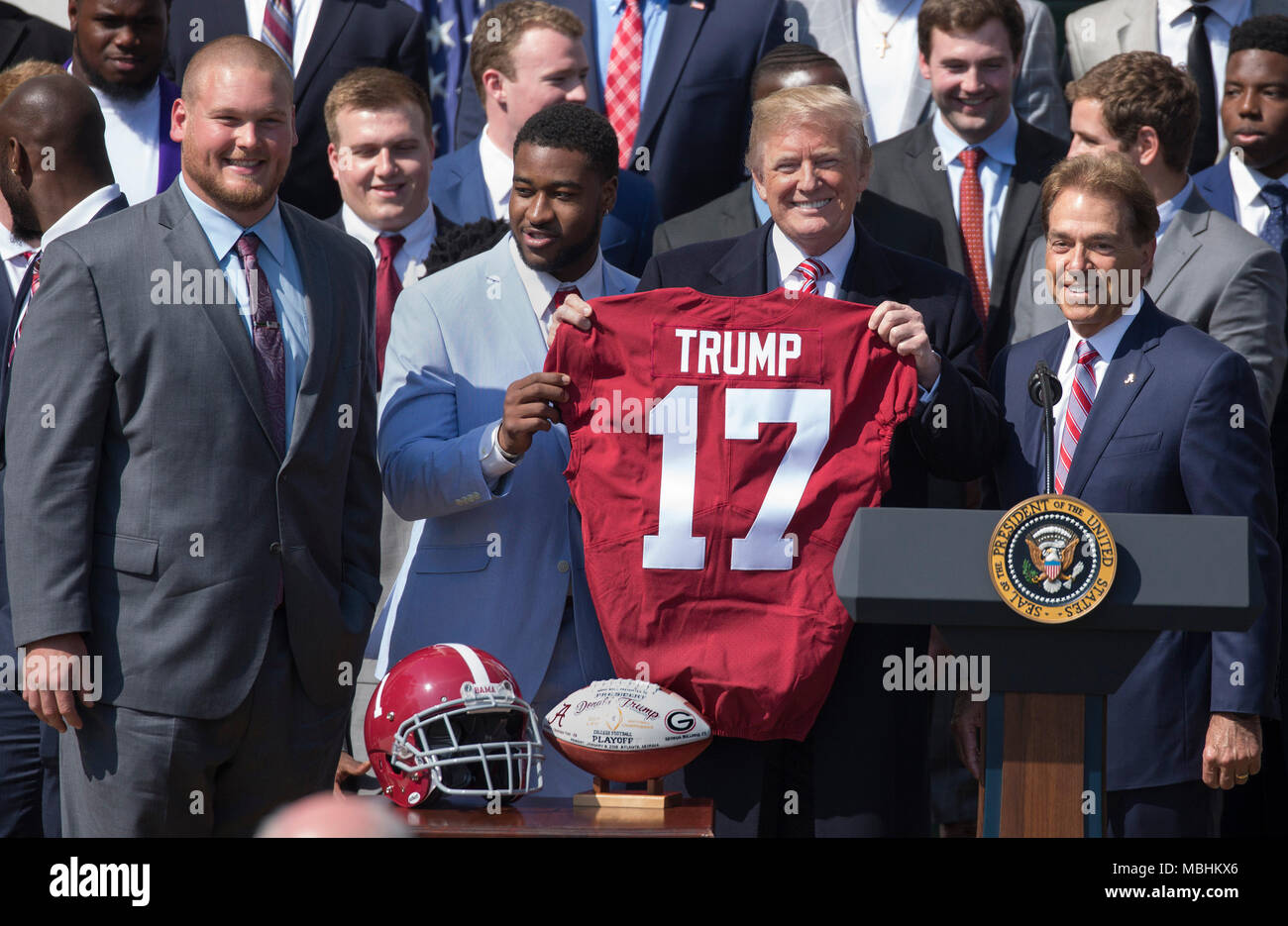 Washington, USA. 10th Apr, 2018. United States President Donald J. Trump  receives a jersey from team members during the welcoming ceremony of the  2017 NCAA Football National Champions: The Alabama Crimson Tide