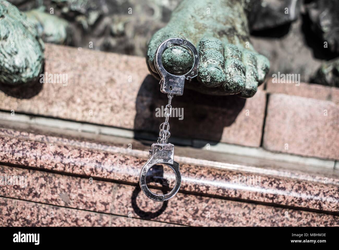 Munich, Bavaria, Germany. 11th Apr, 2018. Handcuffs hanging from the Maxmonument. The Green Party Youth (Gruene Jugend) of Munich, along with 120 members of the SPD, JuSos, Mut Bayern, and die Linke demonstrated against the forthcoming PAG, Police Assignment Laws that give police in Bavaria sweeping secret police-like powers that are alleged to be threats to Germany's model democracy. The CSU party claims the PAG is to protect democracy. The Green Party has threatened complaints based on violations of Germany's Constitution. Credit: ZUMA Press, Inc./Alamy Live News Stock Photo