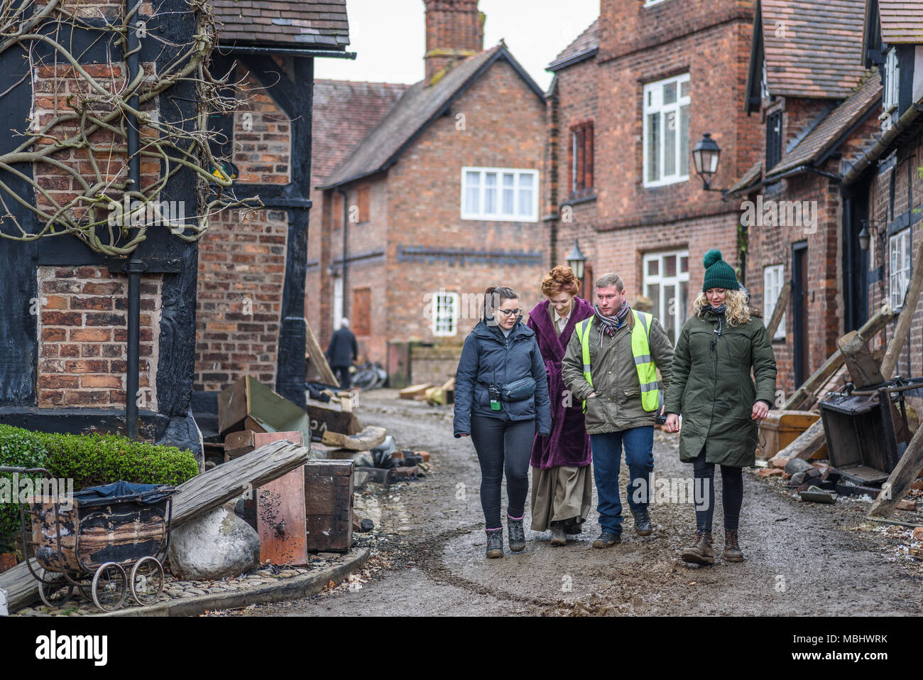 Great Budworth, UK. 11th April, 2018. Actor Eleanor Tomlinson (Amy)  and assistants walk onto set in the new BBC drama 'War Of The Worlds' by HG Wells, filmed in the streets of Great Budworth village, Cheshire on Wednesday afternoon, April 11th. Credit: Ian Hubball/Alamy Live News Stock Photo
