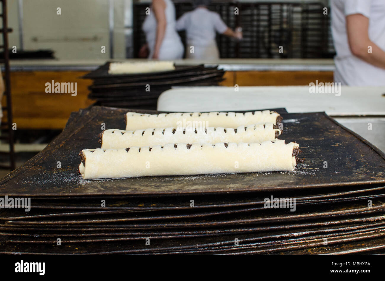 Working on a sweet pastry in a big industrial bakery. Stock Photo
