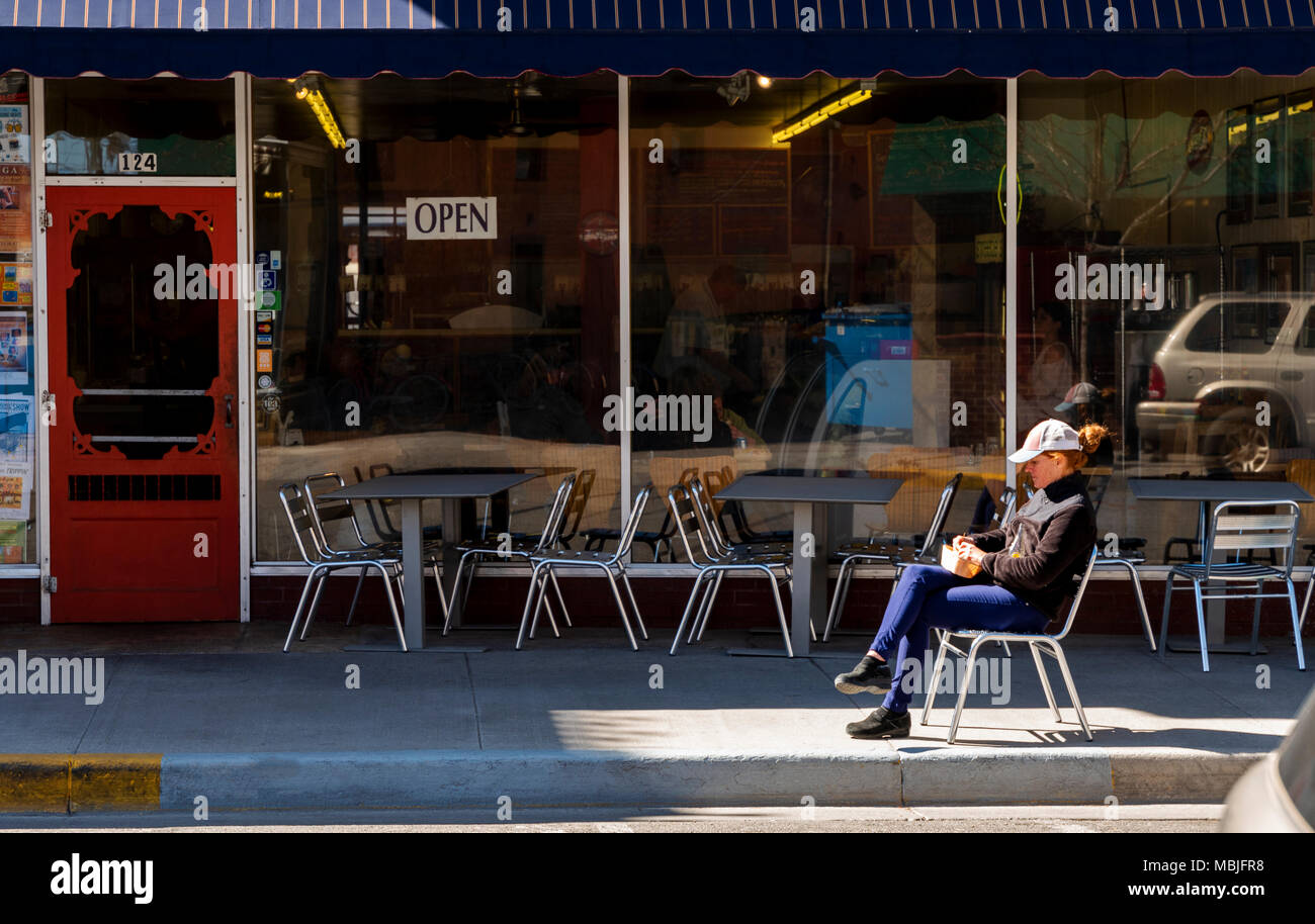 Woman enjoying lunch in sunshine outside Sweetie's Deli; National Historic District; Salida; Colorado; USA Stock Photo