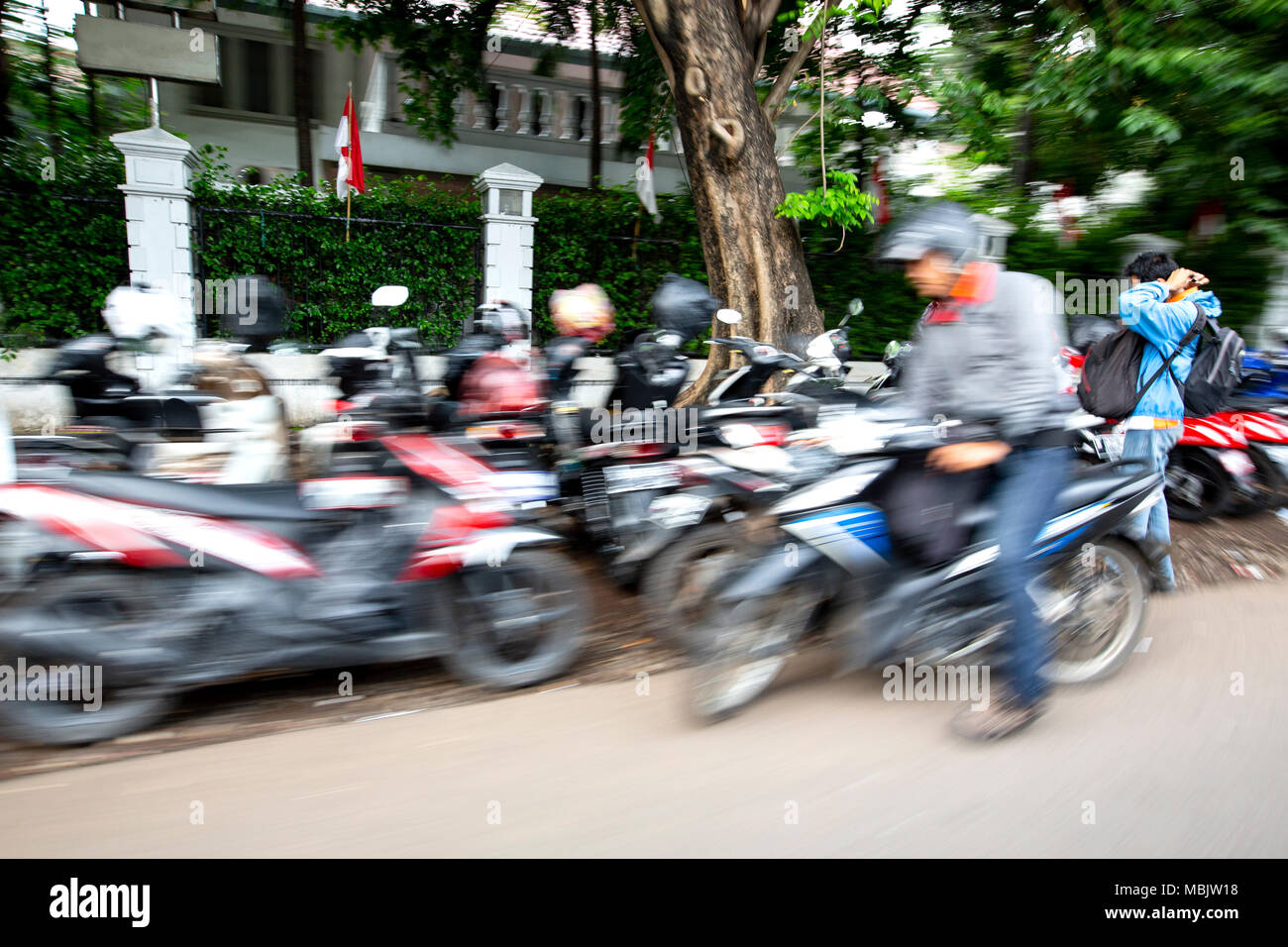 Blur motion motorbikes and riders at the side of the road in Indonesia Stock Photo