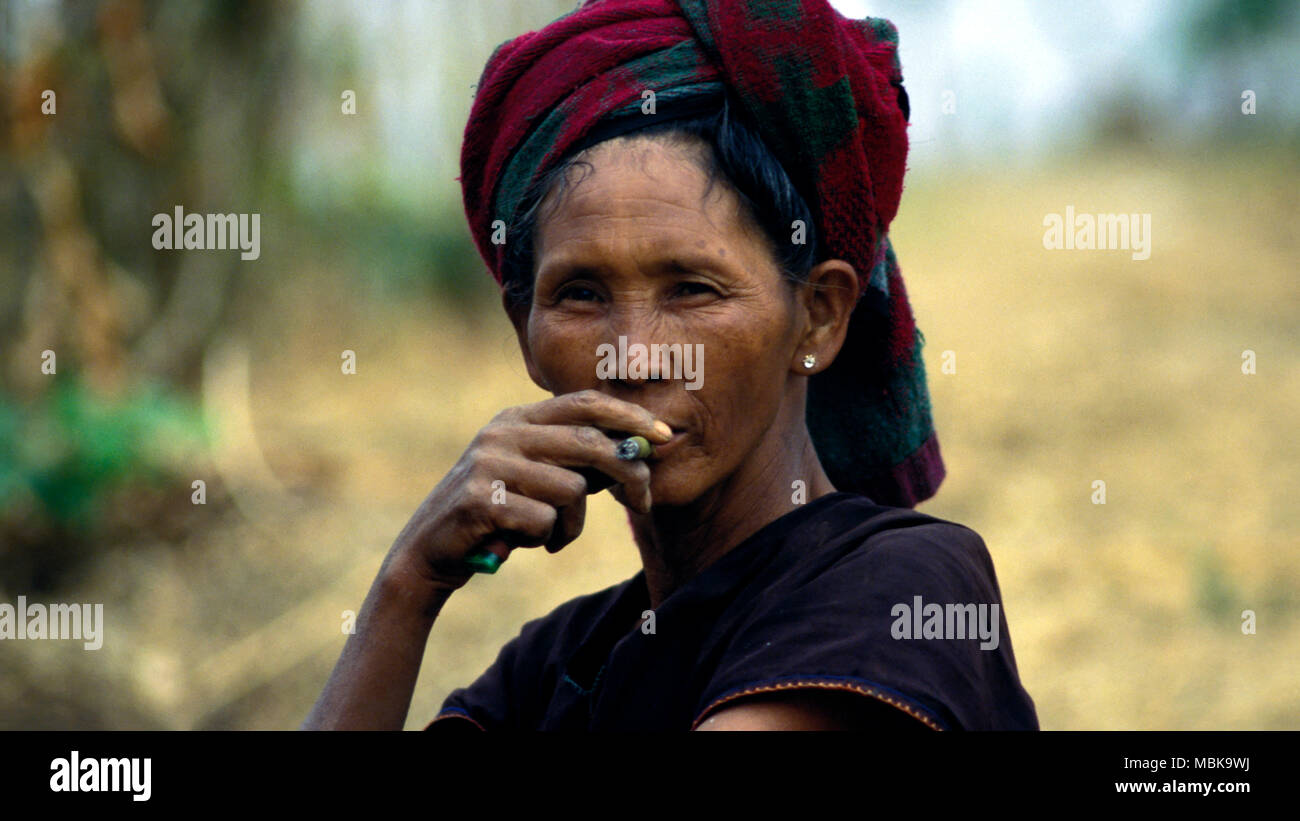 An indigenous Taung-yo woman smoking a cheroot (cigar) while staring at ...