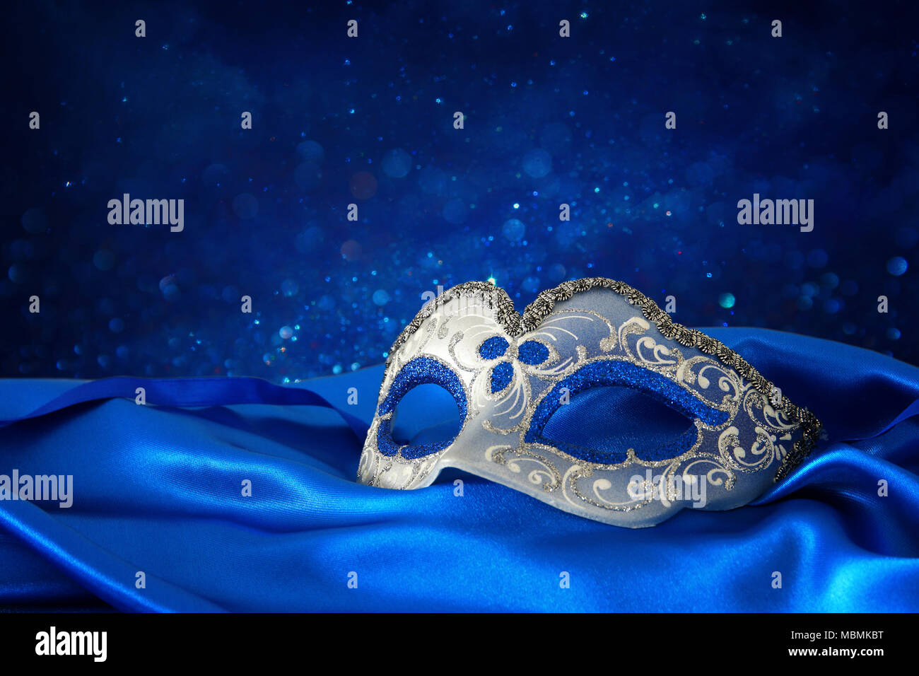 Image of elegant blue and gold venetian mask over blue silk fabric ...