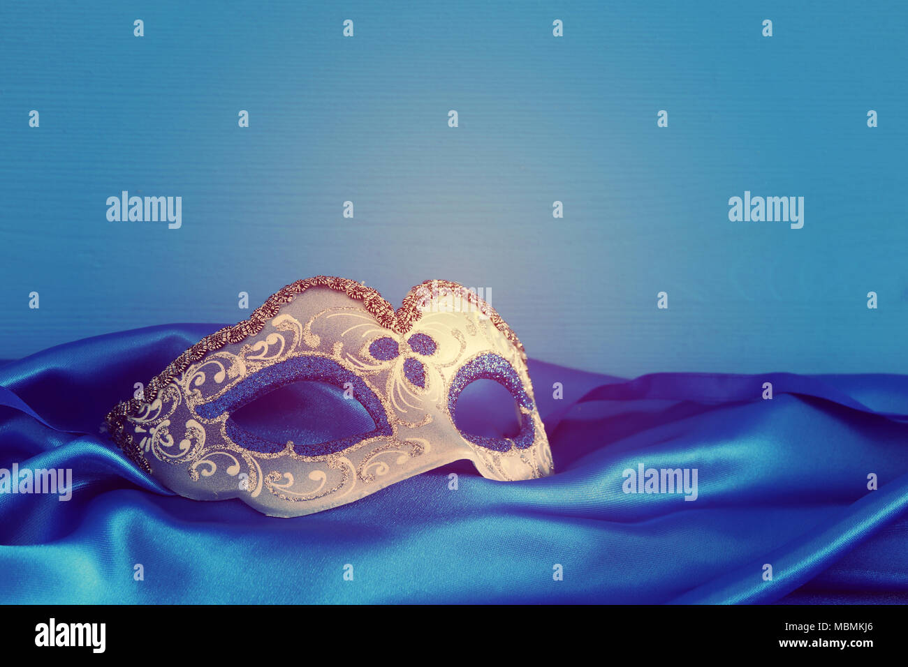 Image of elegant blue and gold venetian mask over blue silk fabric ...