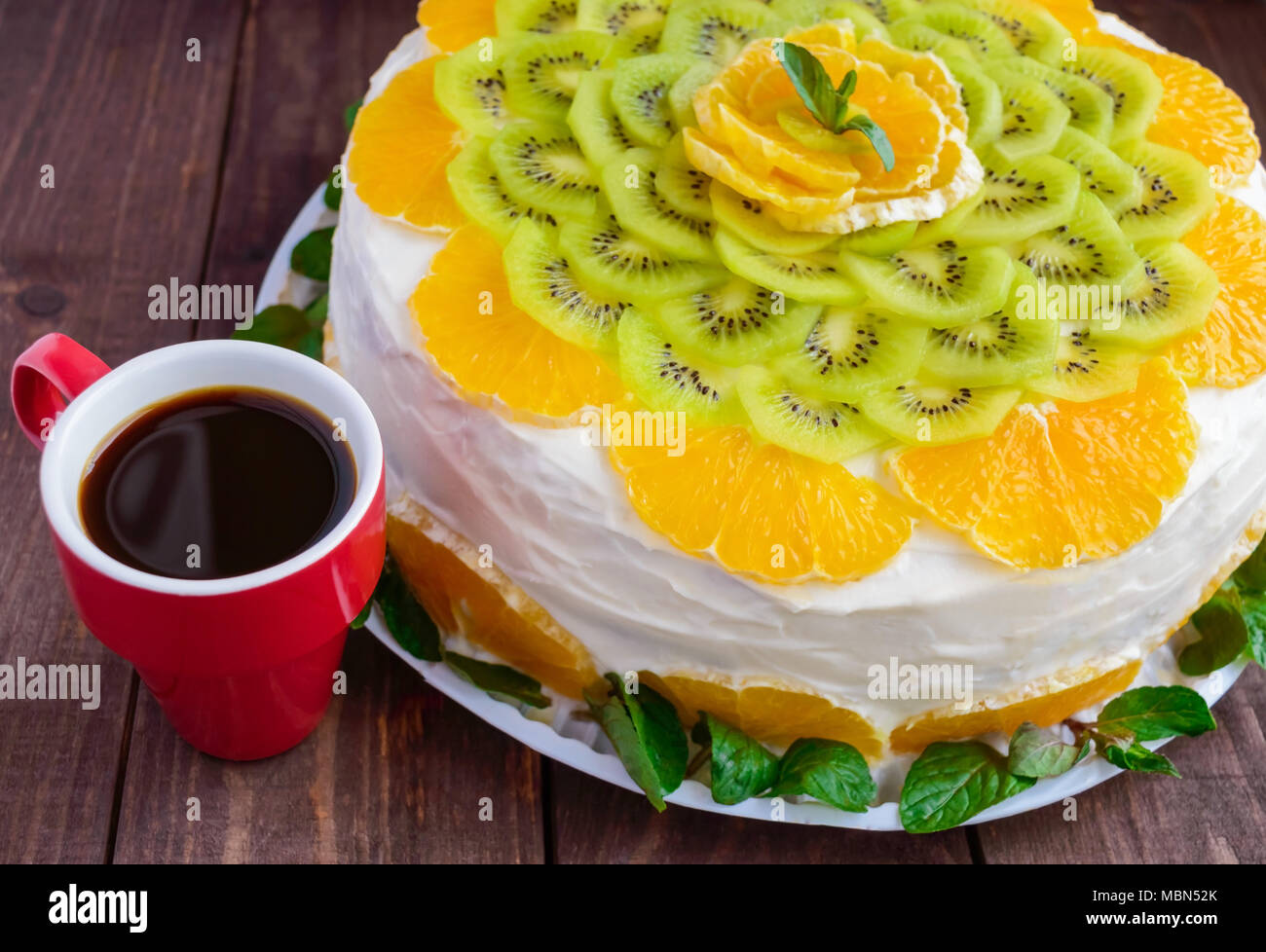 Bright Round Festive Fruit Cake Decorated With Kiwi Orange Mint And A Cup Of Coffee Stock Photo Alamy