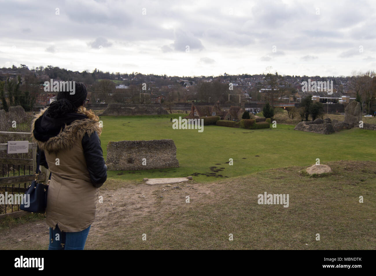 Woman enjoying view of remains of Berkhamsted Castle from the top of the defensive conical mound Stock Photo