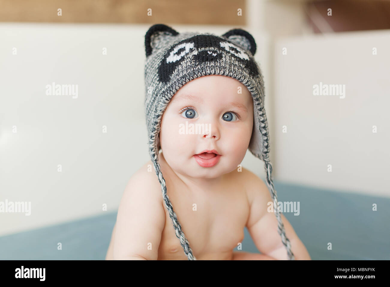Little funny baby boy with big blue eyes smiling with cute cap with