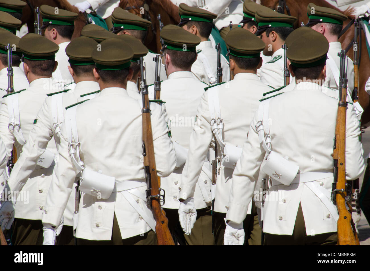 Marching soldiers in white ceremonial uniforms. Military changing of