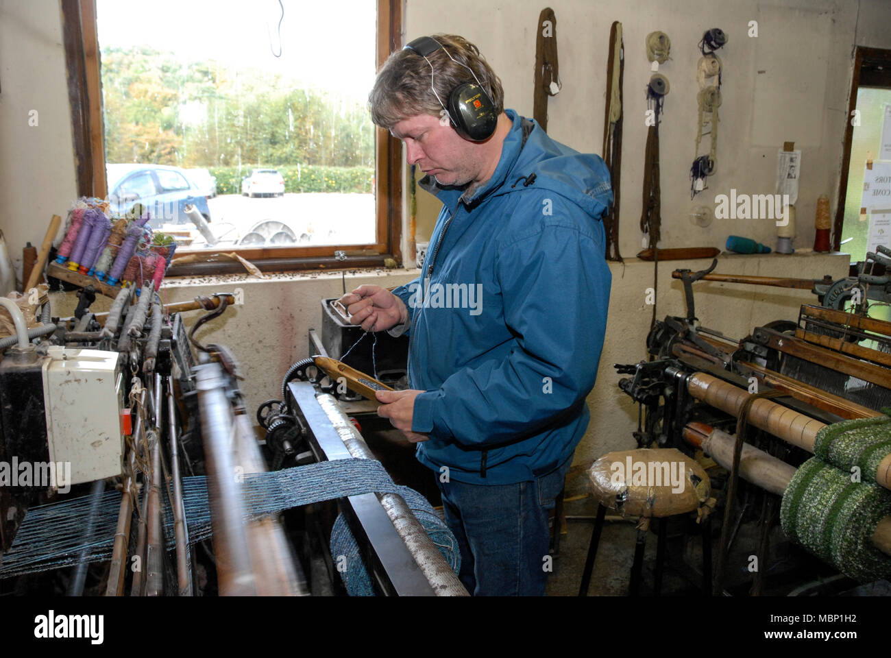 A skilled hand weaver operating a modern weaving loom, producing high
