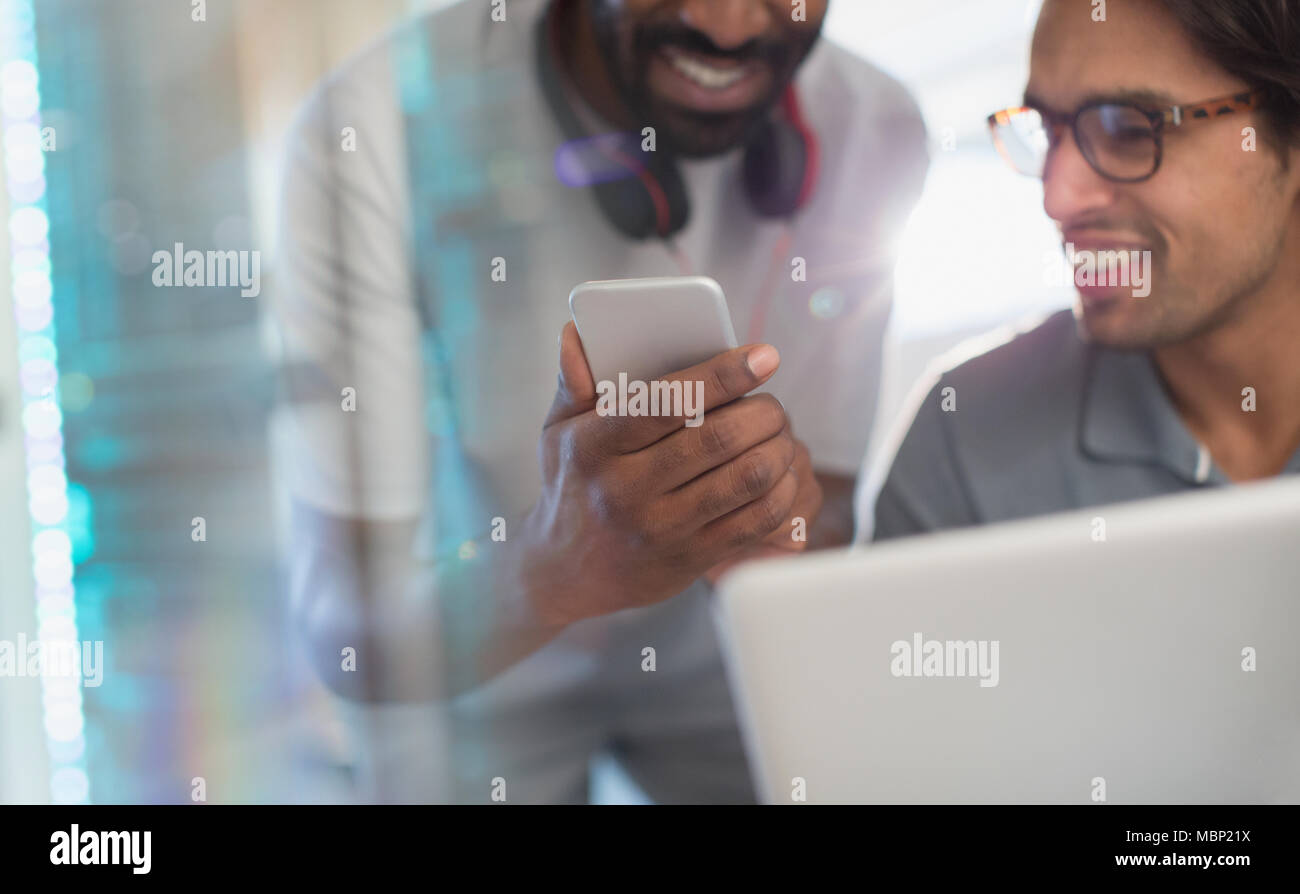 Smiling creative businessmen using smart phone Stock Photo