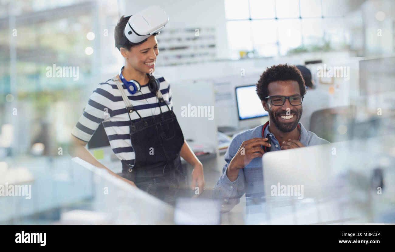 Smiling computer programmers programming virtual reality simulator in office Stock Photo