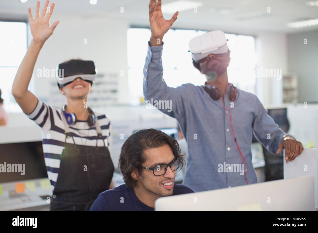 Computer programmers testing virtual reality simulators in office Stock Photo