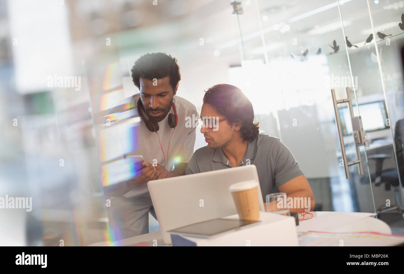 Creative businessmen working at laptop, using smart phone in office Stock Photo
