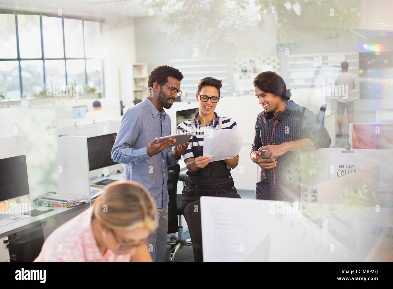 Creative business people with digital tablet discussing paperwork in office Stock Photo