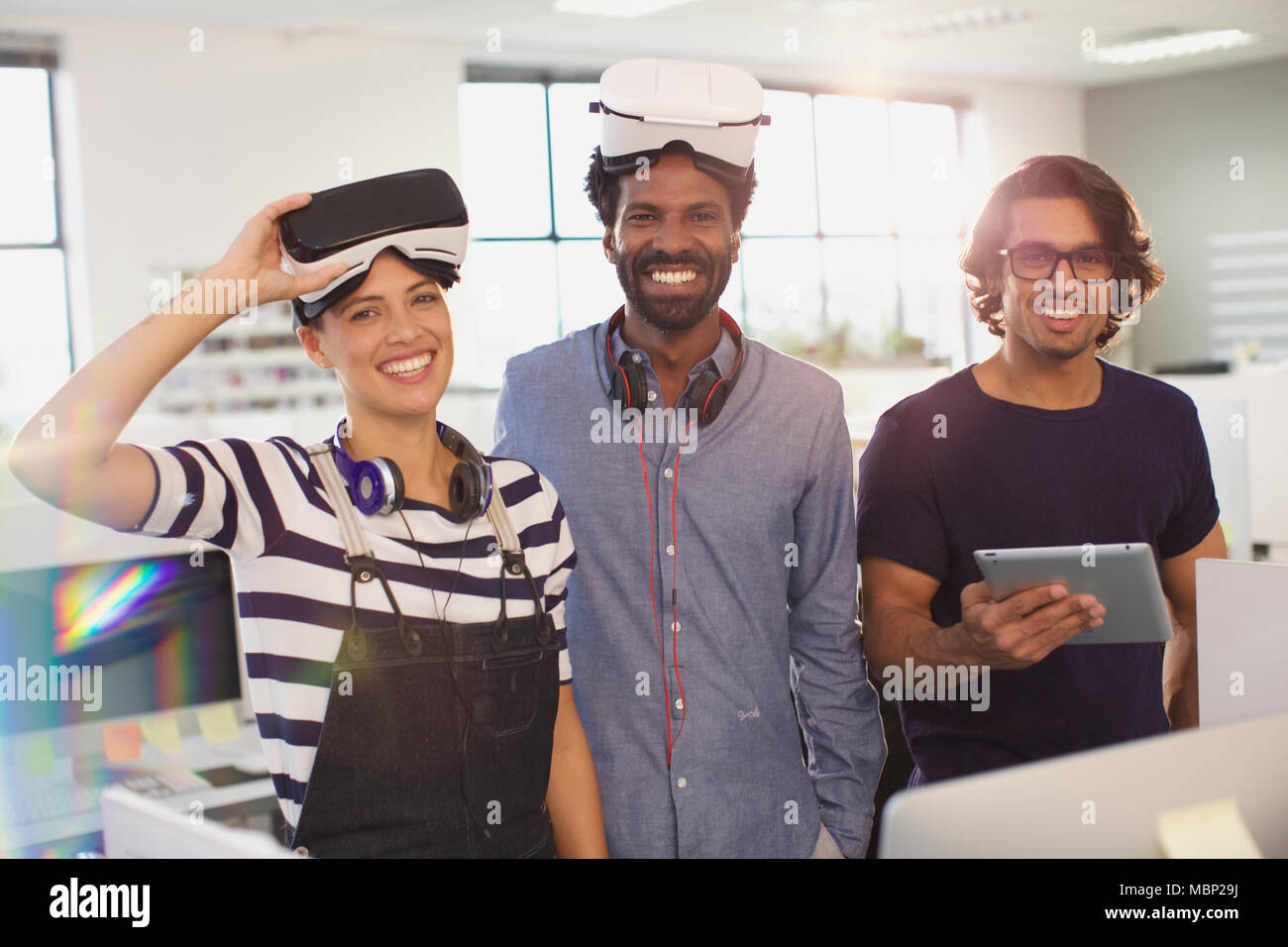 Portrait smiling, confident computer programmers testing virtual reality simulators in office Stock Photo