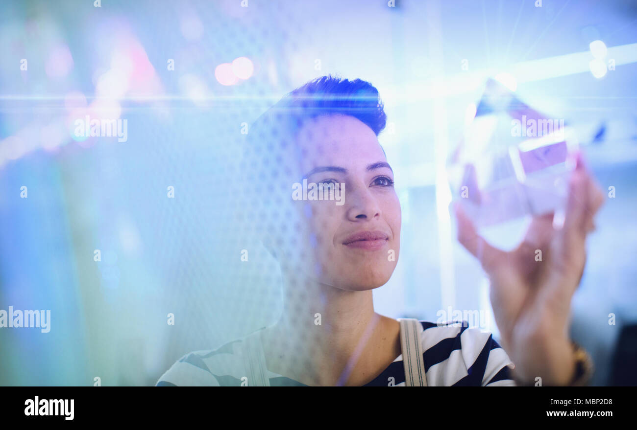 Innovative female entrepreneur examining glass cube prototype Stock Photo