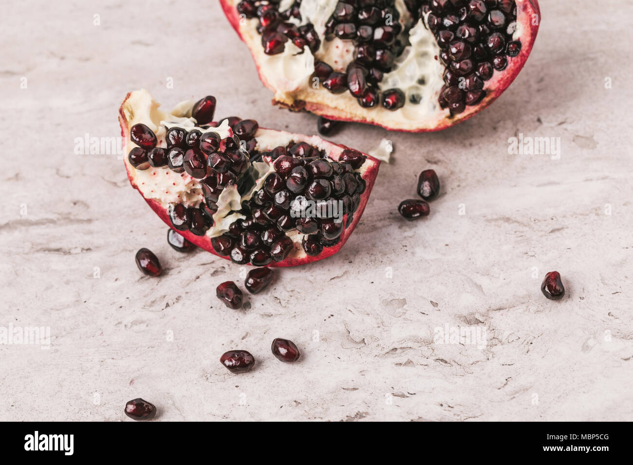 ripe appetizing pomegranate on marble tabletop Stock Photo