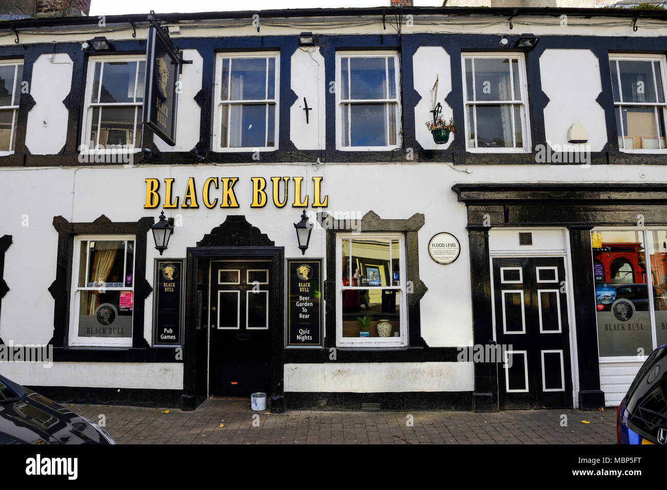 Black Bull public house with wall plaque recording the flood level during the 2009 floods in Cockermouth in the Lake District, Cumbria, England Stock Photo