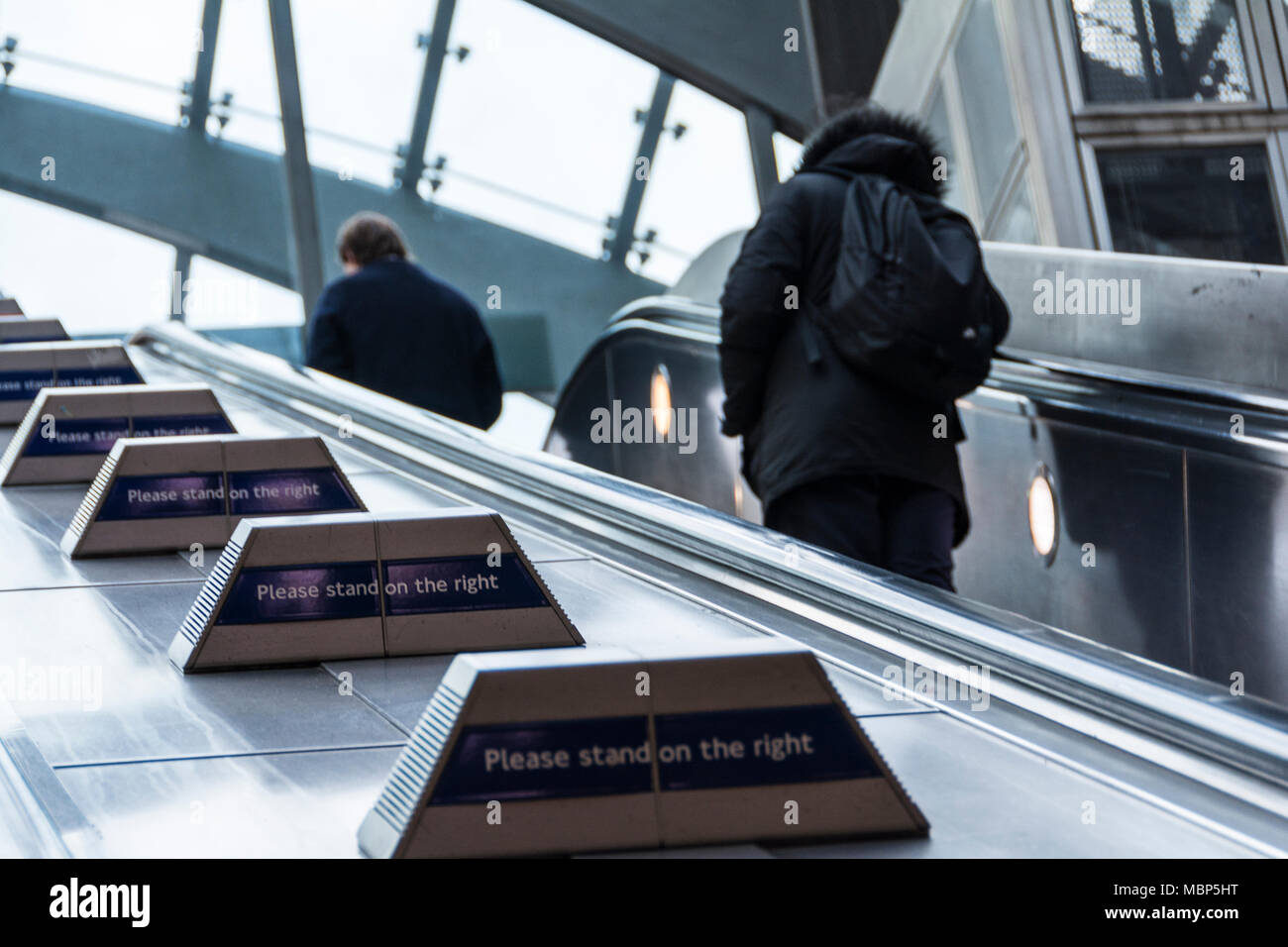 Please Stand on the Right signs on Transport for London escalators at Canary Wharf station, London, UK Stock Photo
