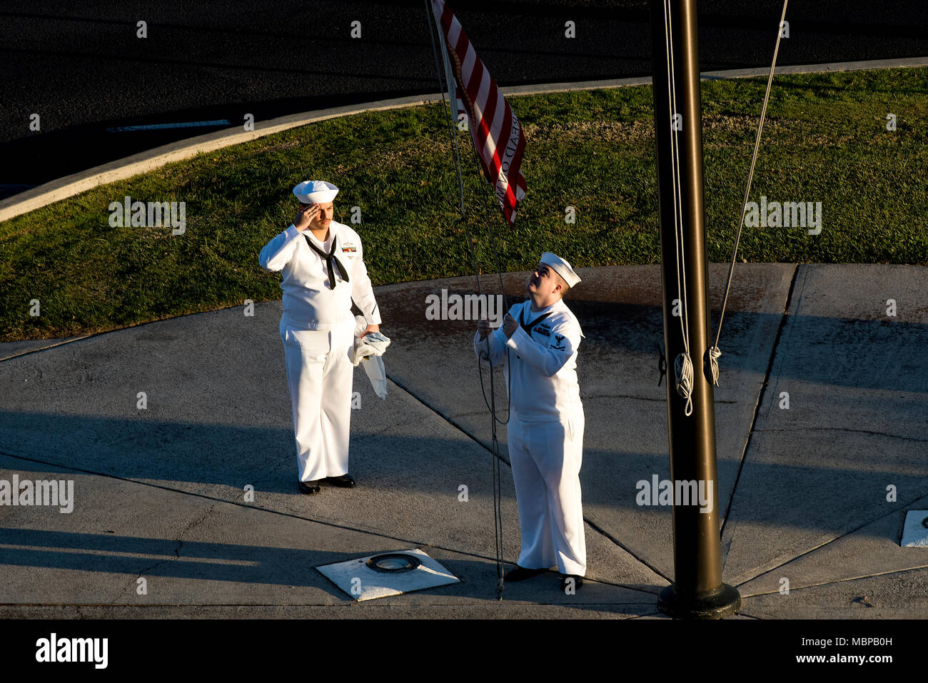 180101-N-QE566-001  PEARL HARBOR - (Jan. 1, 2018) (left to right) Culinary Specialist 2nd Class Gerado Taddei and Yeoman 2nd Class Andrew Thompson fly the "First Navy Jack" to start the New Year on Joint Base Pearl Harbor-Hickam. Rear Adm. Brian Fort, commander, Navy Region Hawaii and Naval Surface Group Middle Pacific, directed the base headquarters building to fly the "First Navy Jack" throughout 2018 to honor the 17 shipmates we lost on USS Fitzgerald (DDG-62) and USS John S. McCain (DDG-56)  and as a reminder that our warfighting edge is not only back but renewed and forged with purpose. ( Stock Photo