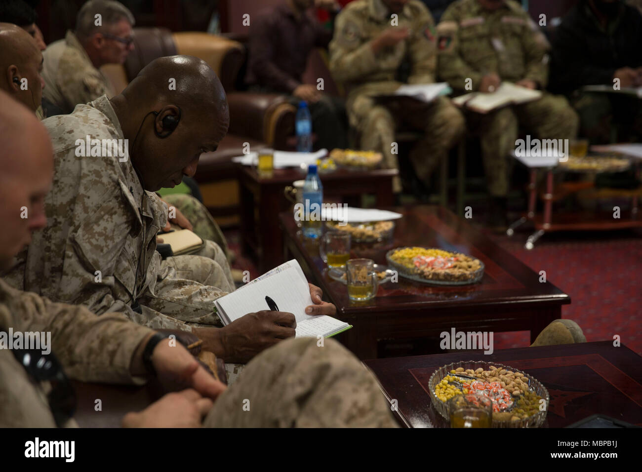U.S. Marine Col. David Gibbs, the Task Force Southwest senior advisor to the 505th Zone Afghan National Police, writes down notes during a shura at Bost Airfield, Afghanistan, Jan.1, 2018. Key leaders from Task Force Southwest and the Afghan National Defense and Security Forces came together to discuss follow-on actions for Maiwand 10 as well as provincial security solutions, further reinforcing the Lashkar Gah security belt and bringing stability to the region. (U.S. Marine Corps photo by Sgt. Justin T. Updegraff) Stock Photo