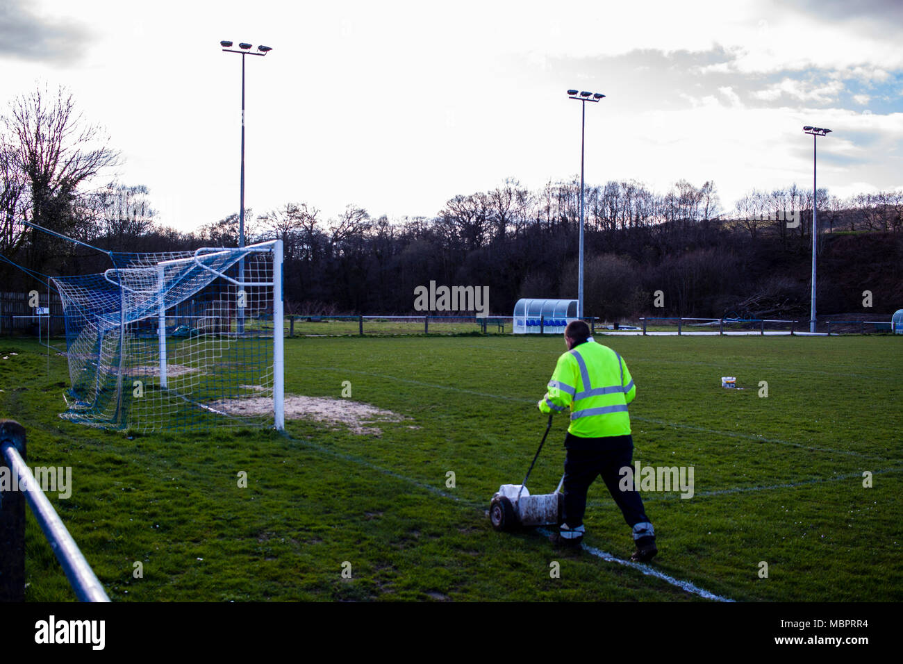 Cwmamman United's Groundsman paints the pitch marking before kick off. Cwmamman United 2-2 Port Talbot Town. Stock Photo