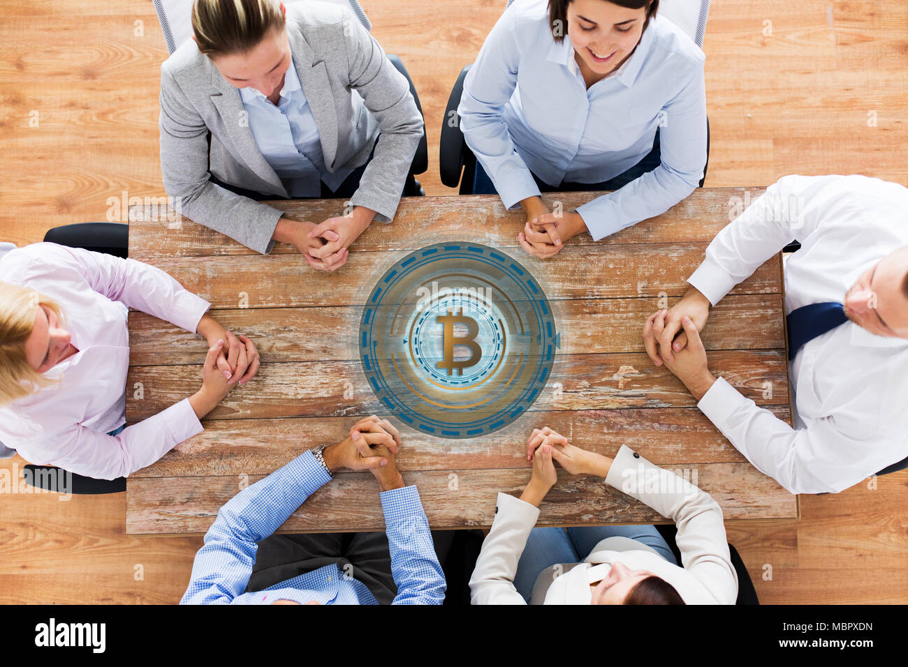 business team at table with bitcoin icon Stock Photo - Alamy