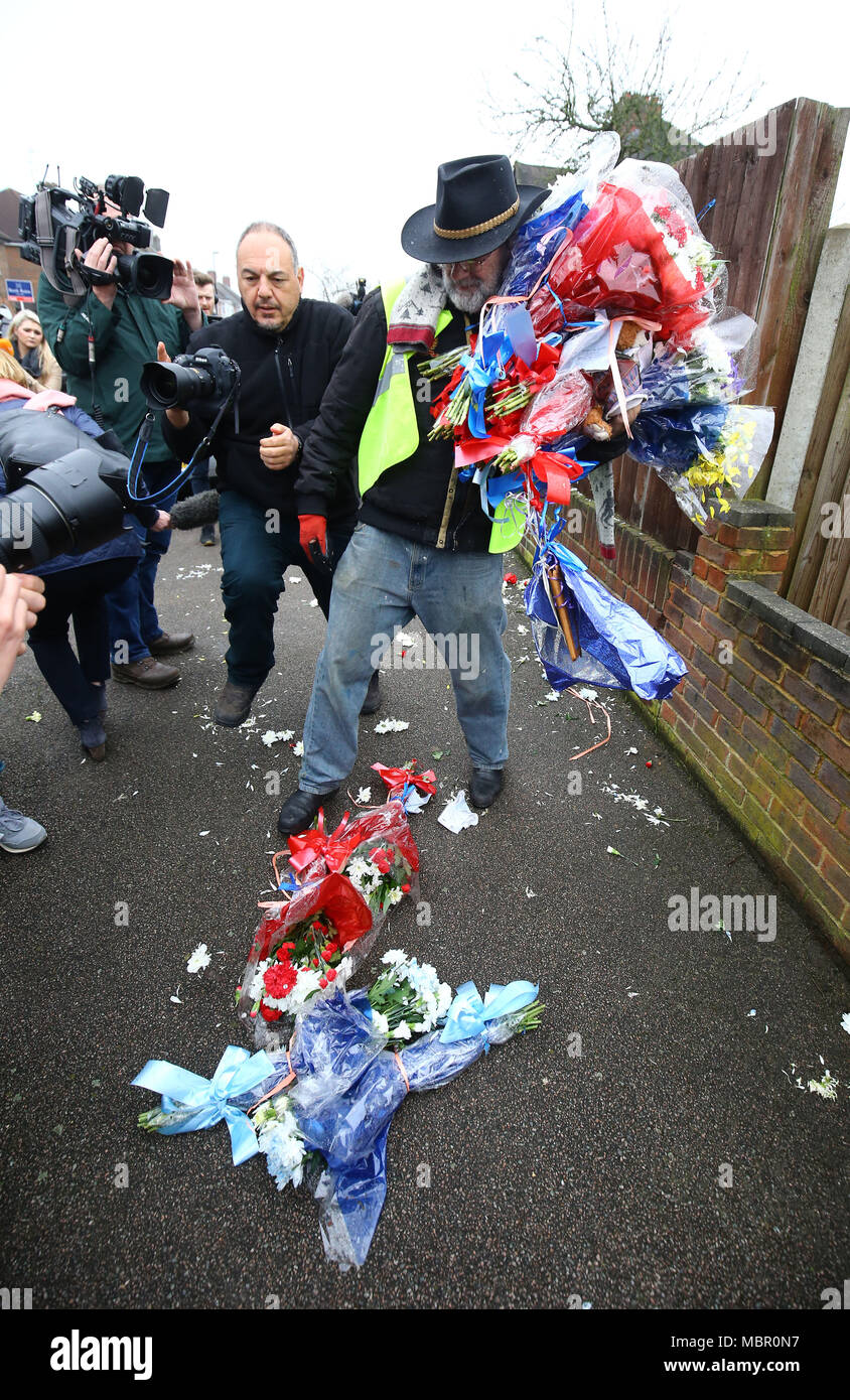Iain Gordon takes flowers away from the scene near the house of Richard Osborn-Brooks in South Park Crescent in Hither Green, London, after it has become an unlikely flashpoint of tensions between the grieving family and his neighbours since last week's incident after burglar Henry Vincent was killed by Richard Osborn-Brooks at his house. Stock Photo