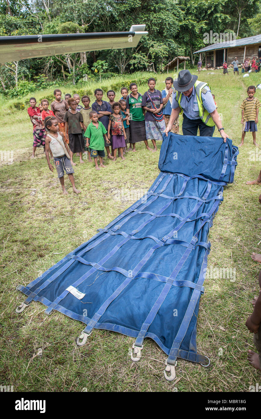 MAF (Mission Aviation Fellowship) pilot folding an aircraft cloth, Wanekipa village, Papua New Guinea Stock Photo