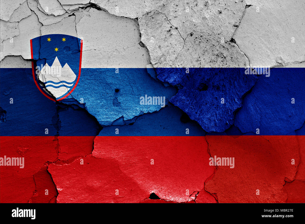 flags of Slovenia and Russia painted on cracked wall Stock Photo