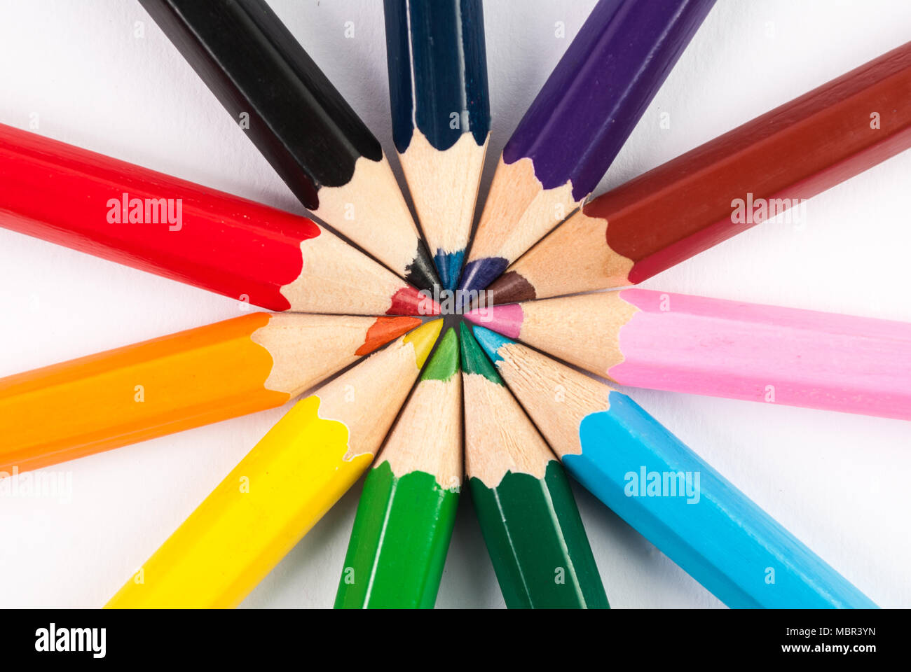 Circle of colored pencils in the colors of rainbow on white
