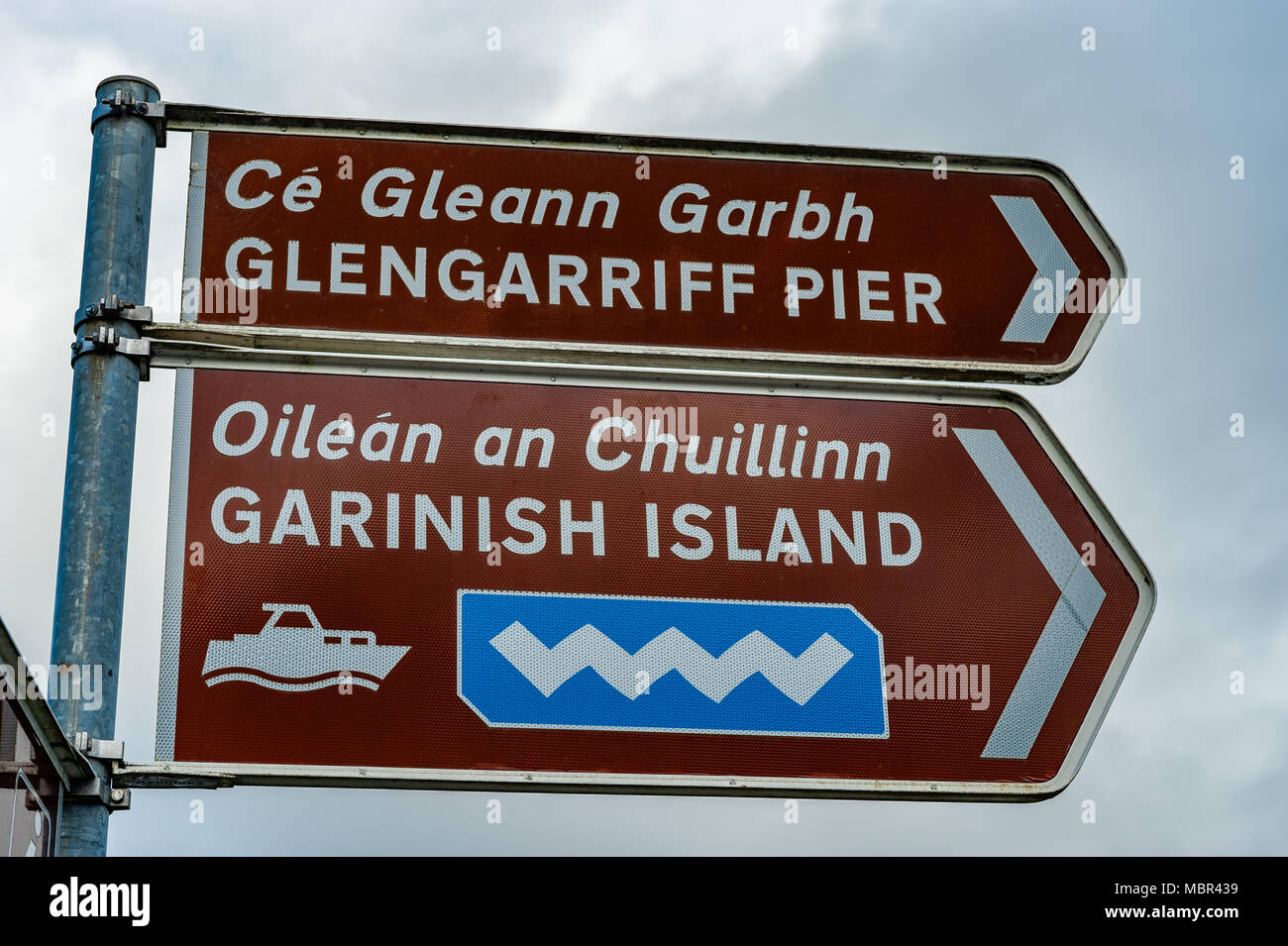 Glengarriff Pier, Garinish Island and Wild Atlantic Way signs on a post in Glengarriff, County Cork, Ireland. Stock Photo