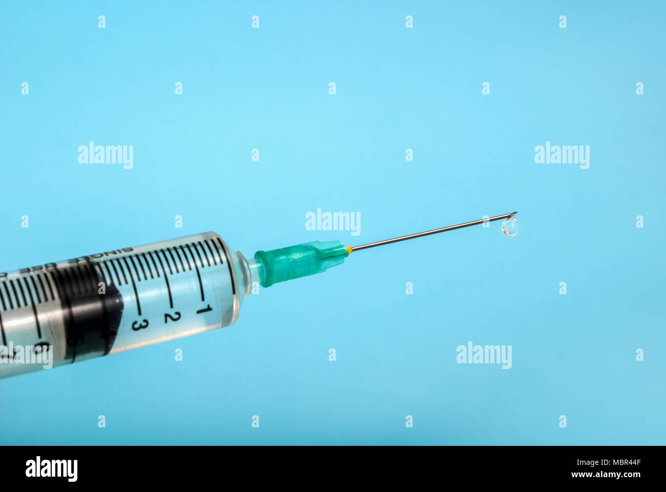 Injection with medicine and needle isolated on a blue background, medical concept Stock Photo
