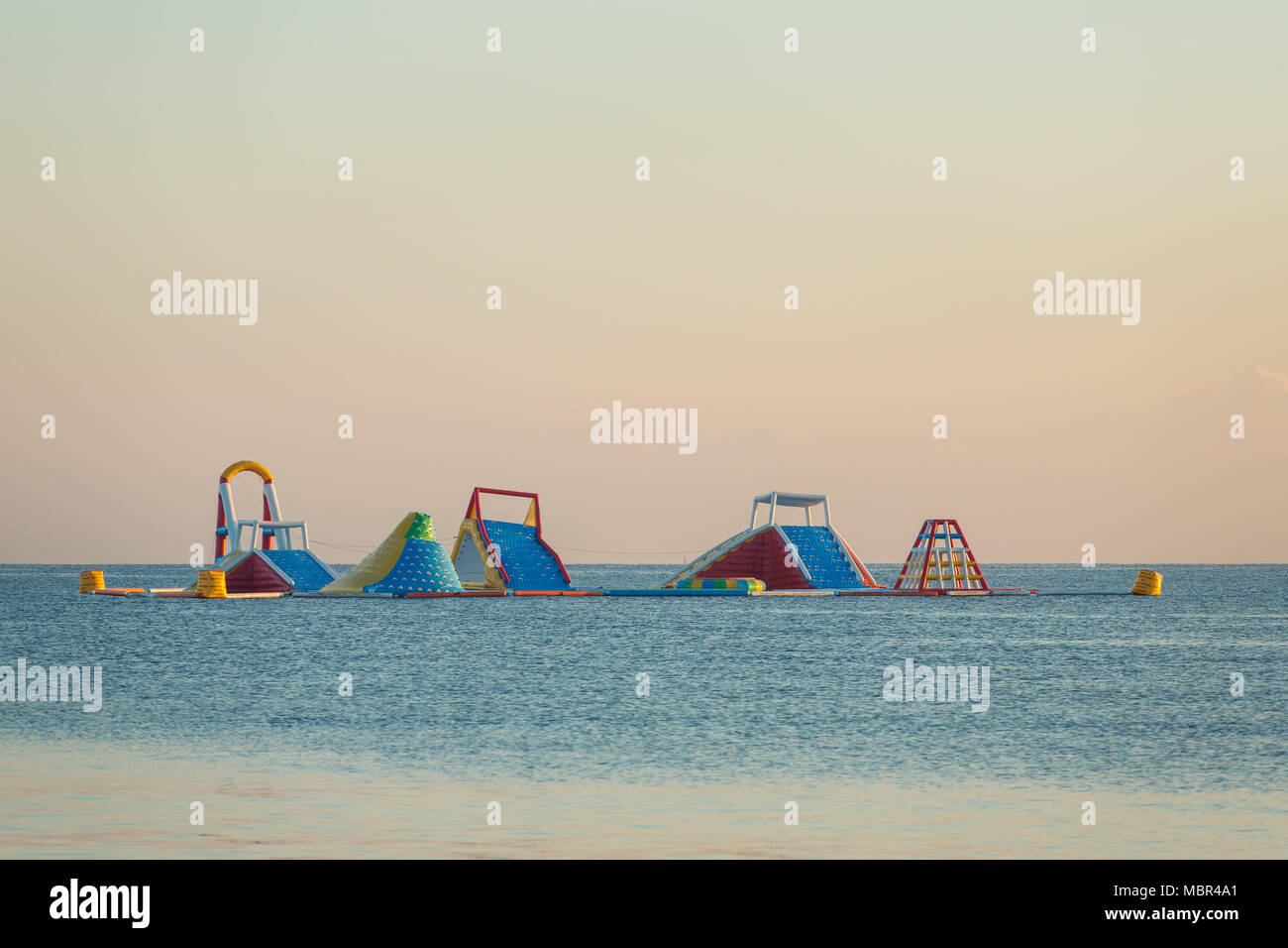 Inflatable floating water park in open sea in Bali Stock Photo