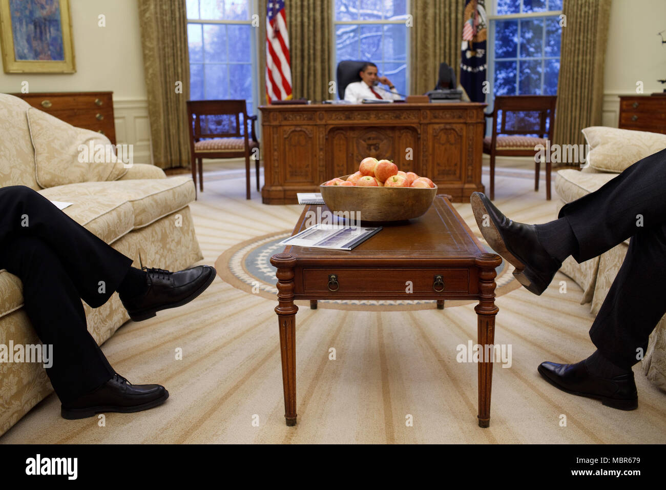 National Security Council staff members sit in the Oval Office while President Obama speaks to foreign leaders 1/27/09. Official White House Photo by Pete Souza Stock Photo