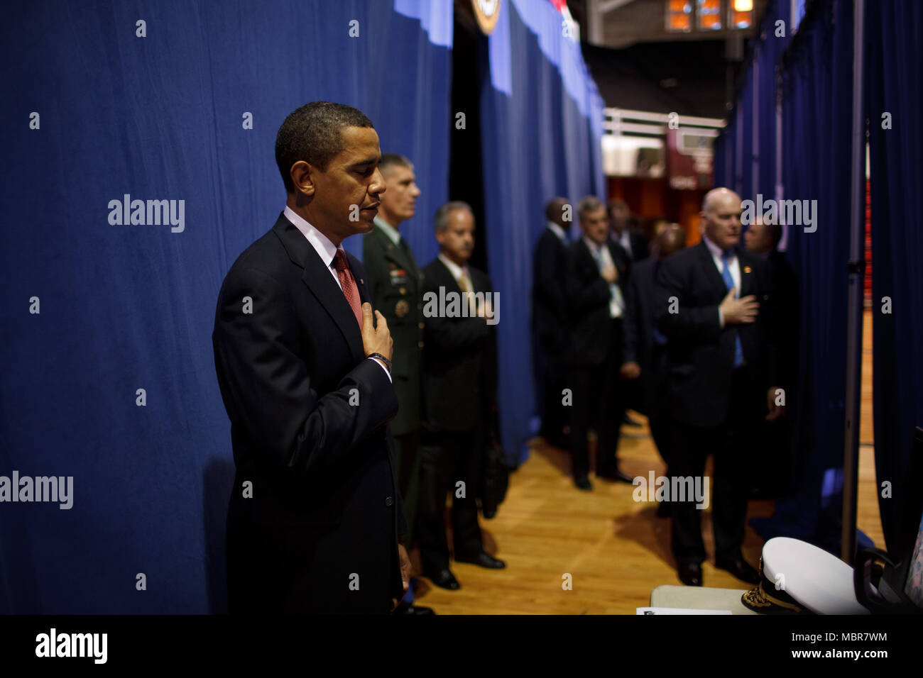 Before giving a policy speech on Iraq, President Barack Obama places his hand on his heart as the national anthem is played backstage  at the Field House, Camp Lejeune, North Carolina 2/27/09. .Official White House Photo by Pete Souza Stock Photo