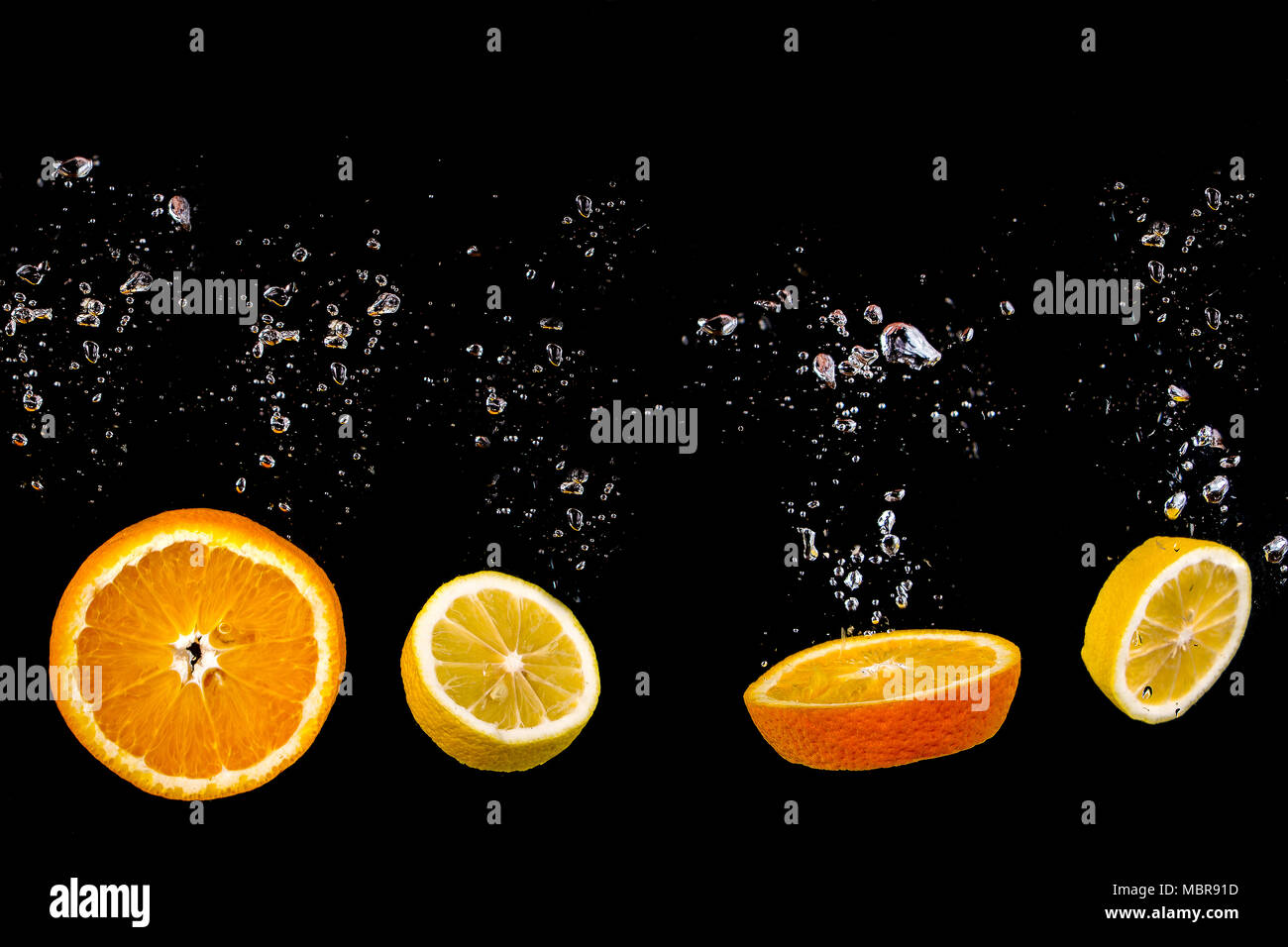 Lemon and orange float in water with bubbles, the fruit is in water